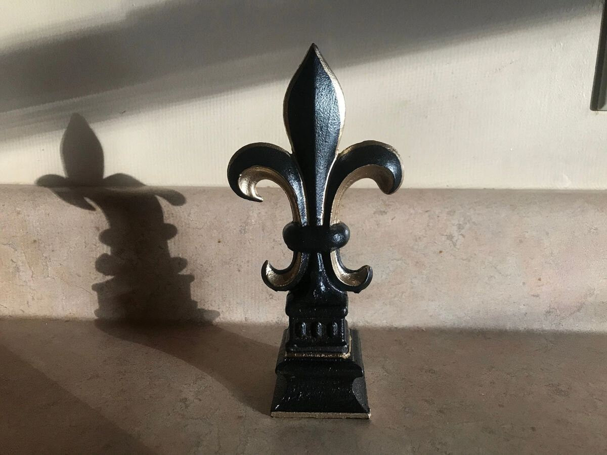 5 1/2 and 7 1/4 high cast iron Fleur de lis on pedestal. Beautifully hand painted with metallic gold accents