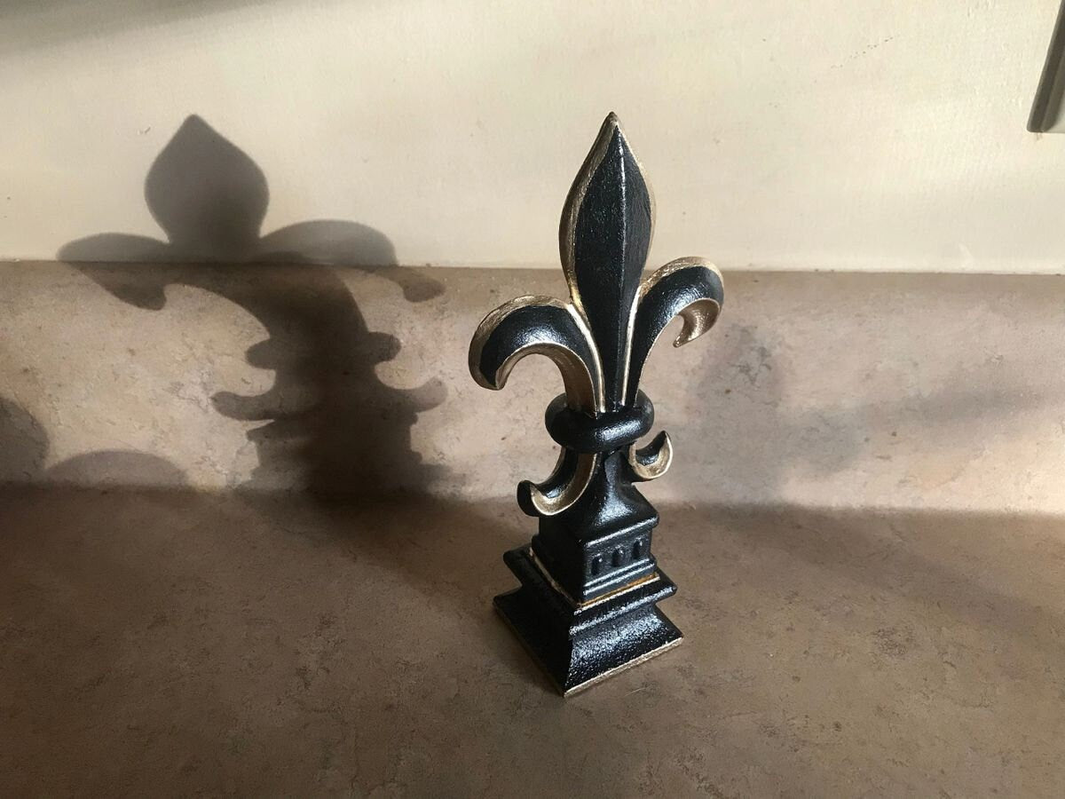 5 1/2 and 7 1/4 high cast iron Fleur de lis on pedestal. Beautifully hand painted with metallic gold accents