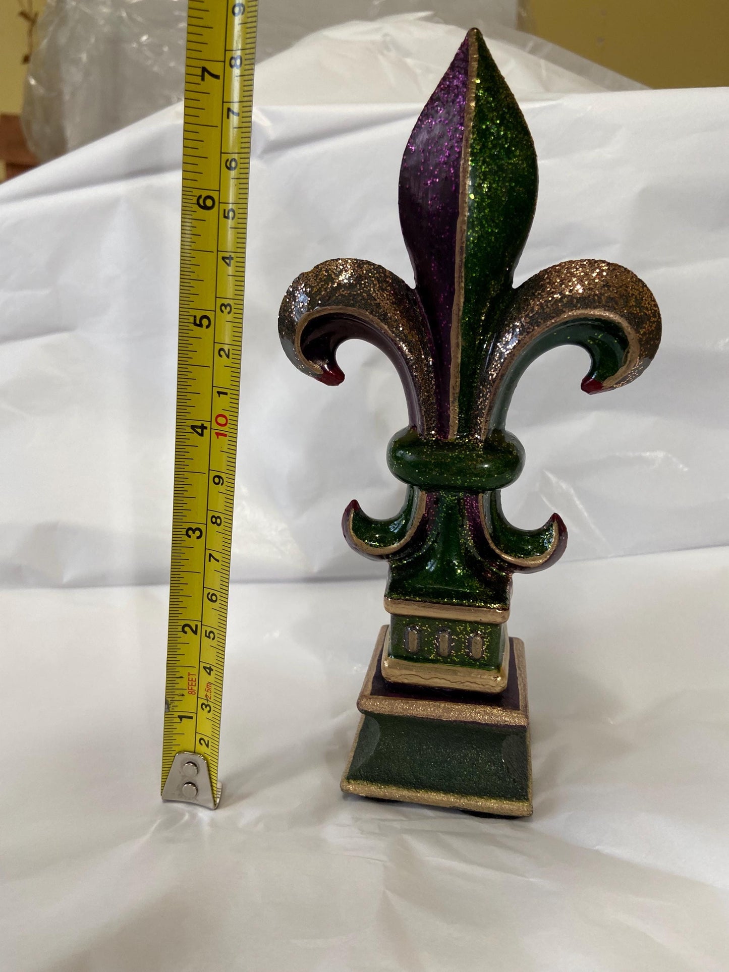 5 1/2 and 7 1/4 high cast iron Fleur de lis on pedestal. Beautifully hand painted with metallic gold accents